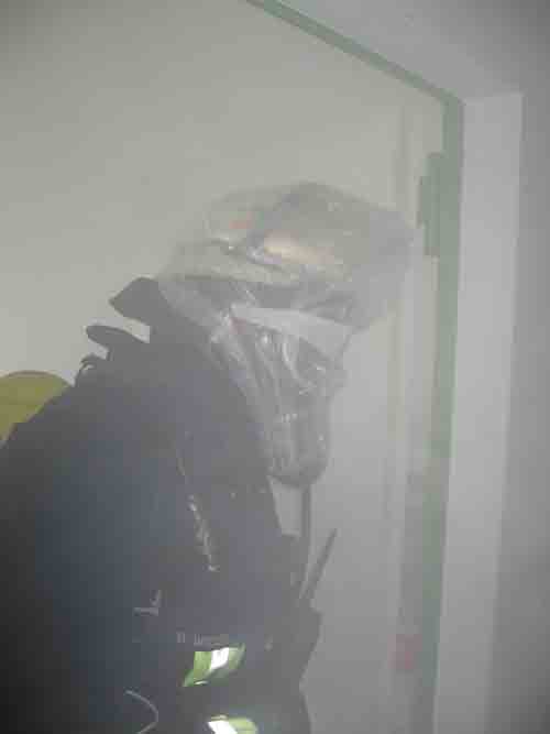 Feuerwehrmann unter PA mit Tte ber der Maske im Rauch